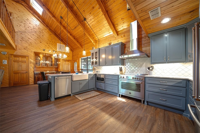 kitchen with wall chimney range hood, high vaulted ceiling, kitchen peninsula, pendant lighting, and appliances with stainless steel finishes