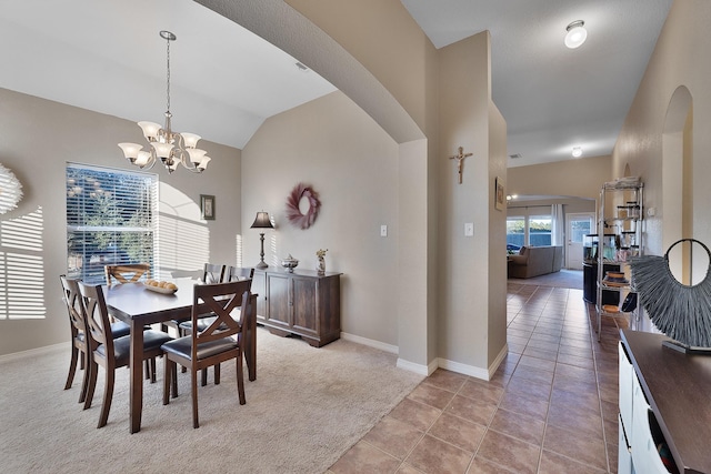 dining room featuring a notable chandelier, light tile patterned flooring, and vaulted ceiling