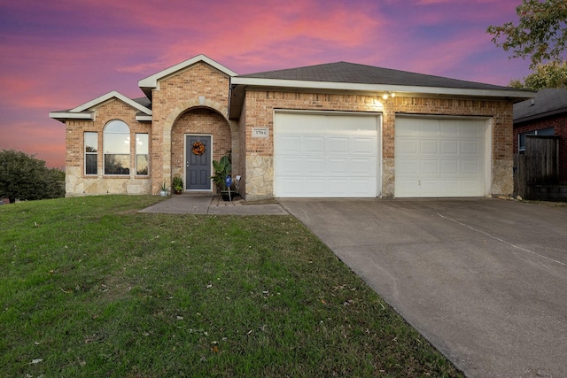 ranch-style house with a garage and a yard