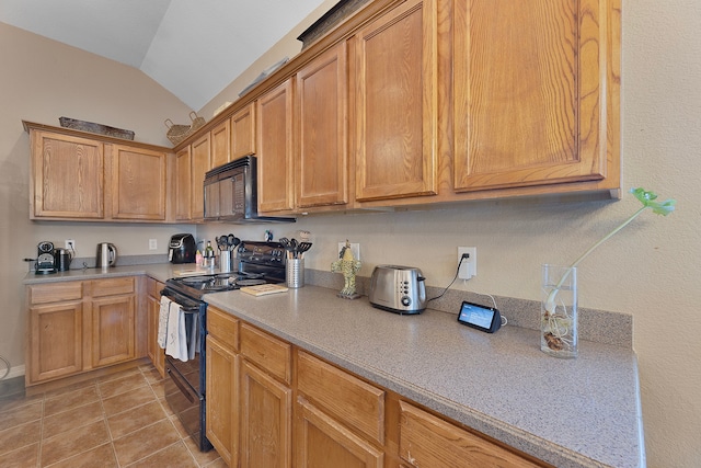 kitchen with vaulted ceiling, light tile patterned flooring, and black appliances