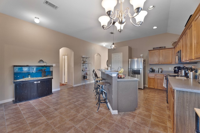 kitchen with a center island, lofted ceiling, hanging light fixtures, stainless steel appliances, and a chandelier