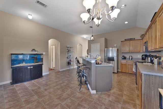 kitchen with stainless steel refrigerator with ice dispenser, lofted ceiling, decorative light fixtures, range, and a kitchen island