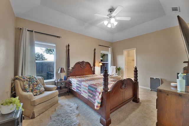 carpeted bedroom with vaulted ceiling, a raised ceiling, and ceiling fan