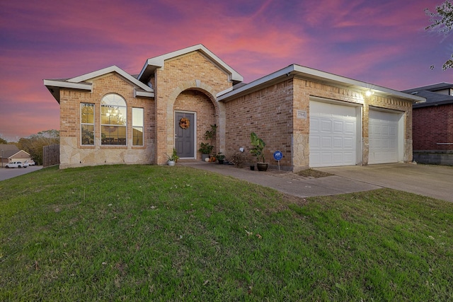 view of front of property with a garage and a lawn