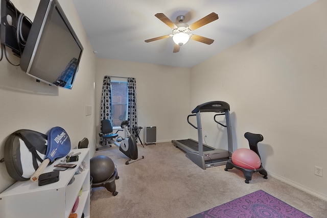 workout room with ceiling fan and light colored carpet