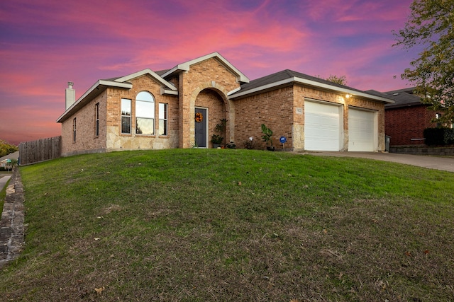 view of front of house featuring a garage and a lawn