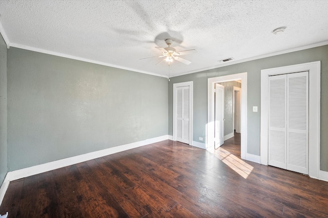 unfurnished bedroom with ceiling fan, a textured ceiling, and dark wood-type flooring