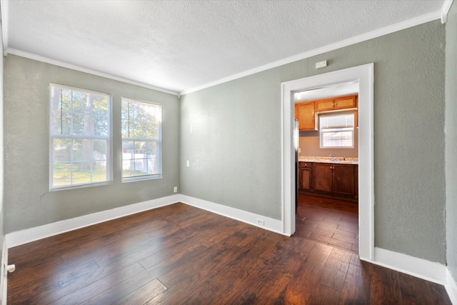 unfurnished room with a textured ceiling, crown molding, sink, and dark hardwood / wood-style floors