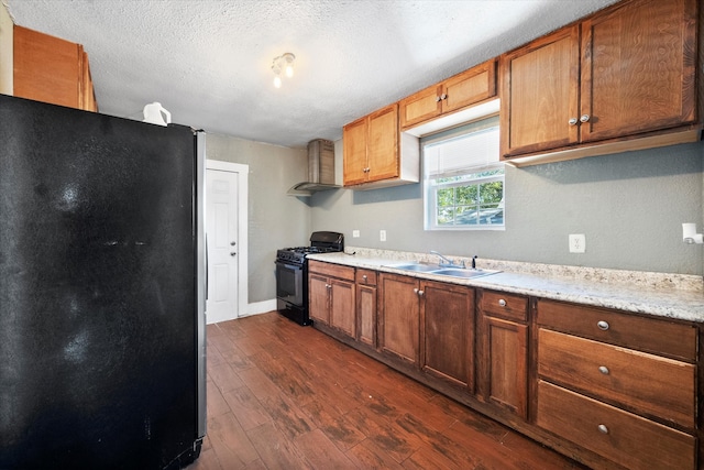 kitchen featuring black appliances, wall chimney range hood, sink, a textured ceiling, and dark hardwood / wood-style flooring