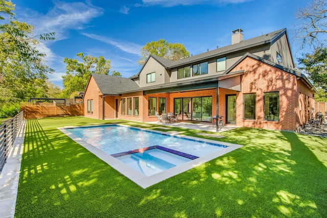 back of house with a lawn, brick siding, and a fenced backyard