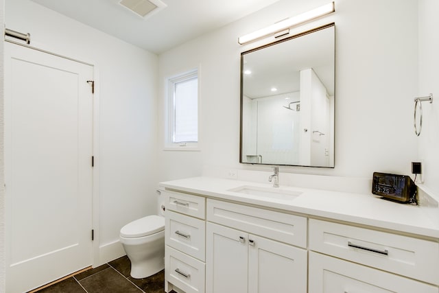 bathroom featuring tile patterned flooring, vanity, toilet, and walk in shower