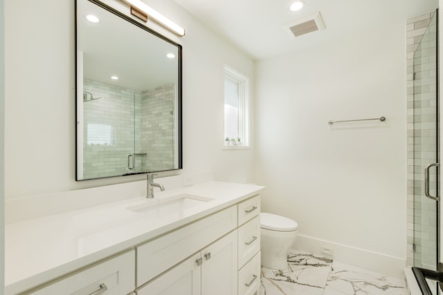 bathroom with a shower with door, vanity, and toilet