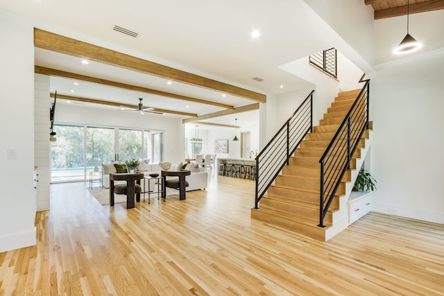 interior space featuring ceiling fan, beamed ceiling, and hardwood / wood-style flooring