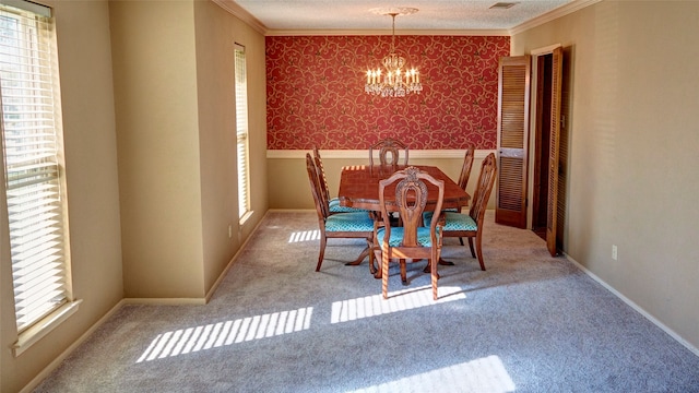 unfurnished dining area featuring a chandelier, light carpet, a textured ceiling, and crown molding