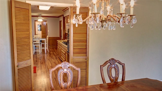 dining area with ceiling fan, wood-type flooring, and crown molding