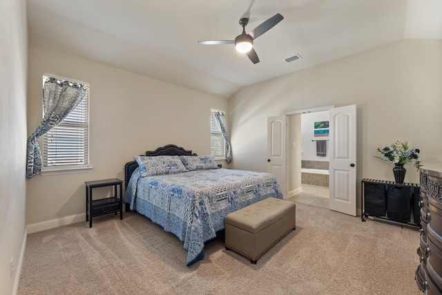 carpeted bedroom featuring ceiling fan, lofted ceiling, and ensuite bath