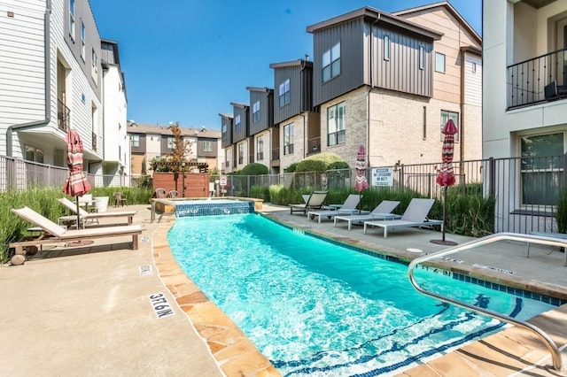 view of swimming pool featuring a hot tub and a patio