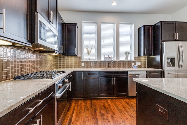 kitchen featuring light stone countertops, sink, dark hardwood / wood-style floors, and appliances with stainless steel finishes