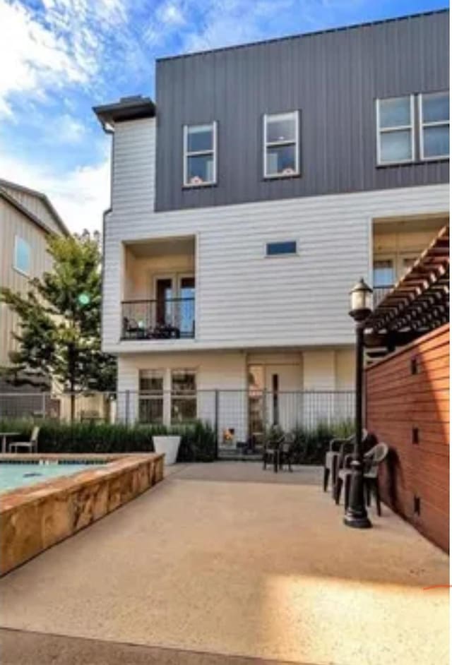 back of property featuring a pool and a patio