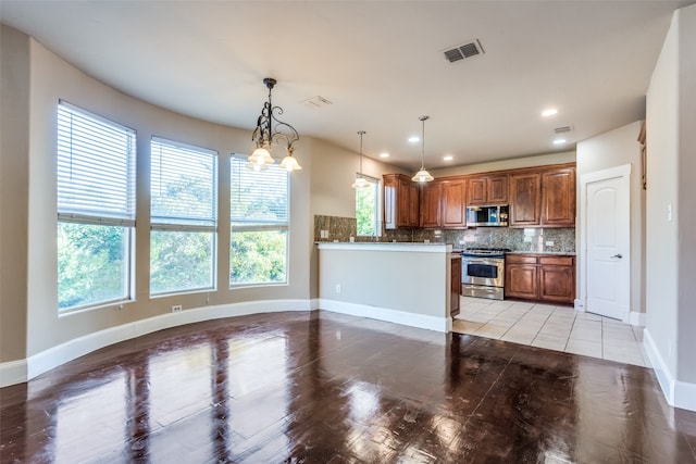 kitchen featuring hanging light fixtures, stainless steel appliances, an inviting chandelier, decorative backsplash, and light wood-type flooring