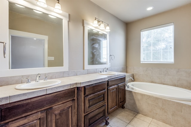 bathroom with vanity, tile patterned floors, and tiled tub