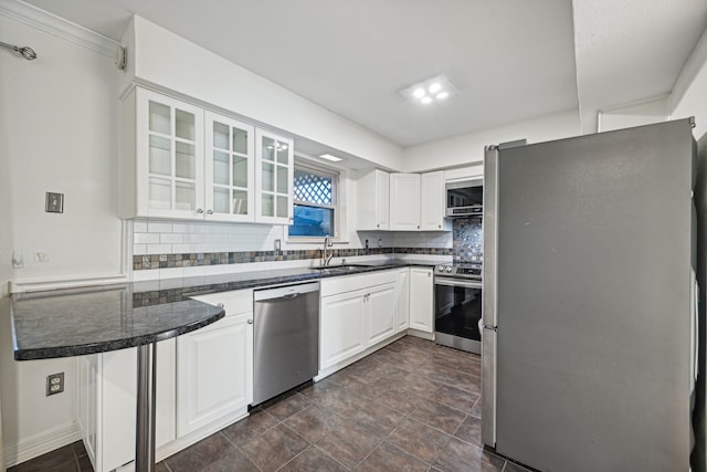 kitchen with white cabinets, appliances with stainless steel finishes, decorative backsplash, and sink