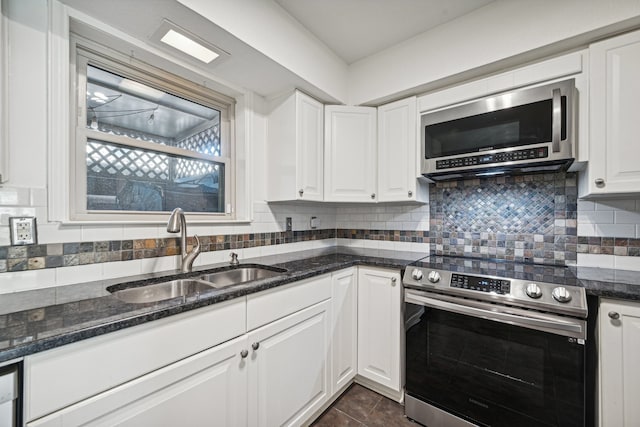 kitchen with appliances with stainless steel finishes, backsplash, white cabinetry, and sink