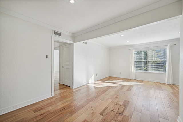 spare room featuring crown molding and light hardwood / wood-style flooring