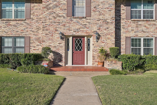 property entrance with a lawn