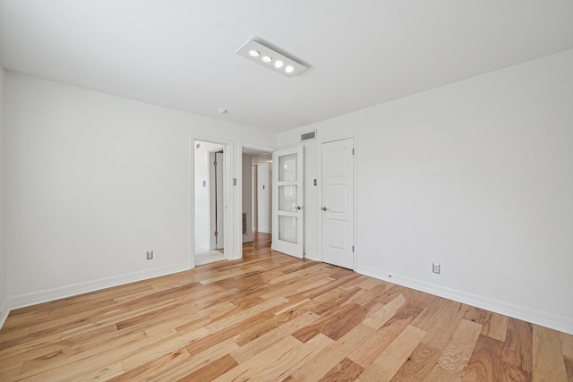 unfurnished room with light wood-type flooring