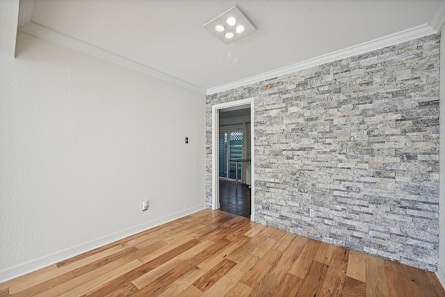 spare room with hardwood / wood-style floors and crown molding