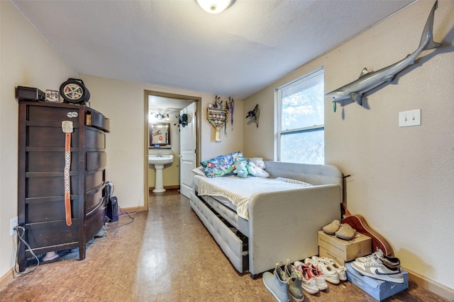 1347 Wild Rd, Van Alstyne, TX 75495 - bedroom with tile patterned floors, ensuite bathroom, and a textured ceiling