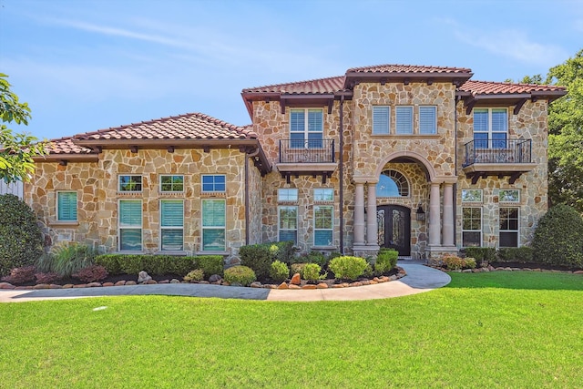 mediterranean / spanish-style home with a balcony and a front yard