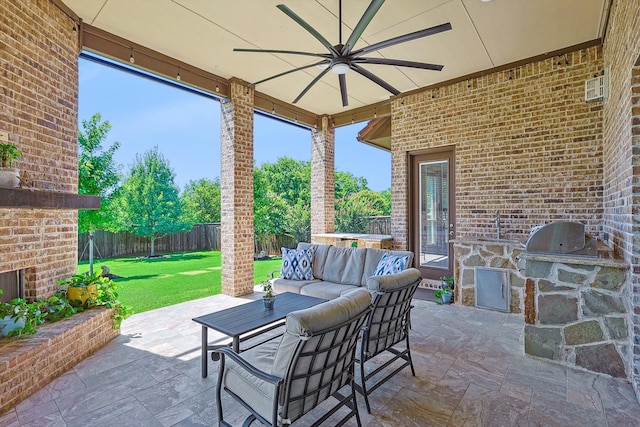 view of patio with an outdoor living space with a fireplace, ceiling fan, and area for grilling