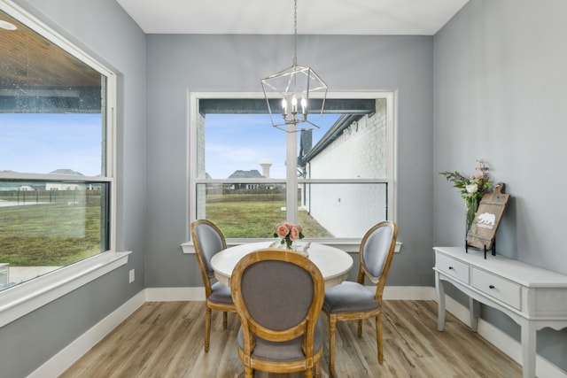 dining room featuring light wood-type flooring and a notable chandelier