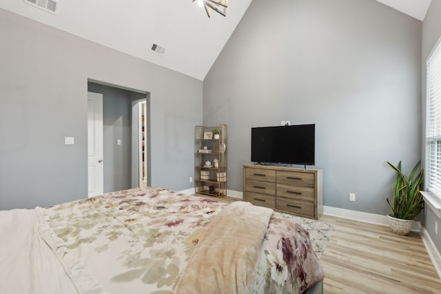 bedroom with high vaulted ceiling and light hardwood / wood-style flooring