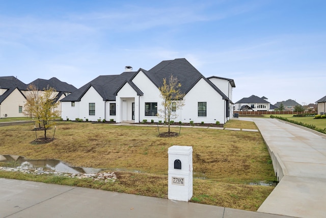 modern inspired farmhouse with a front lawn