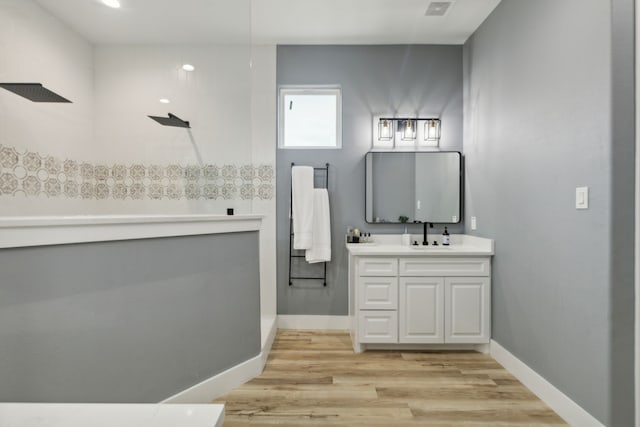 bathroom featuring a shower, vanity, and hardwood / wood-style flooring