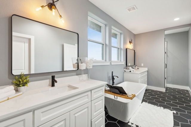 bathroom featuring vanity, tile patterned floors, and a tub