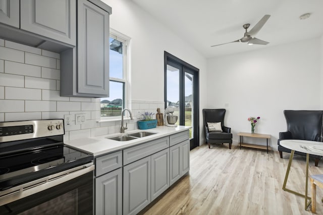 kitchen with gray cabinetry, electric stove, sink, and tasteful backsplash