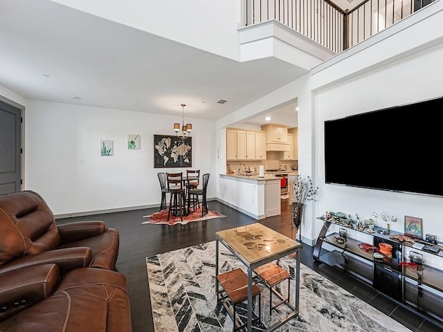 living room featuring a chandelier, sink, dark wood-type flooring, and a high ceiling