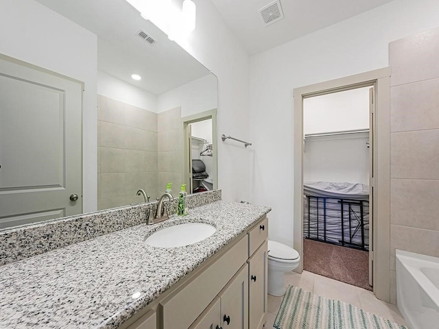 bathroom with toilet, vanity, tile patterned floors, and a washtub