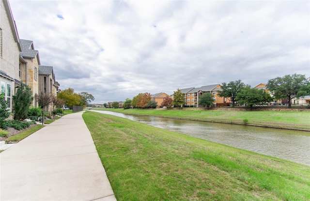 view of community with a lawn and a water view