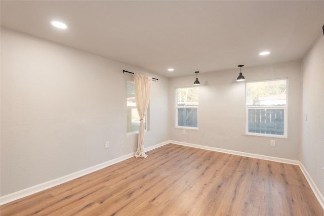 empty room featuring light wood-style flooring, baseboards, and recessed lighting