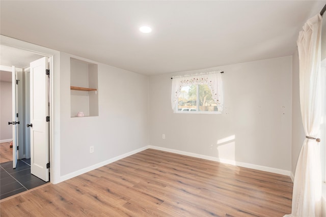 empty room with dark wood-type flooring and baseboards