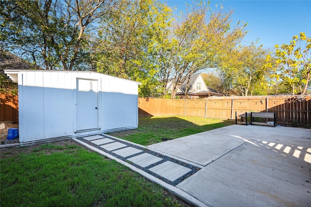 view of yard featuring a patio area, a fenced backyard, an outdoor structure, and a storage shed