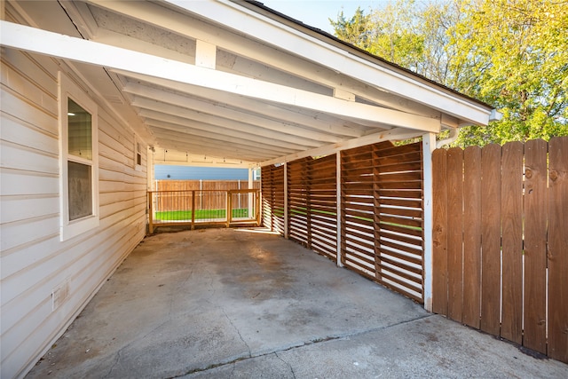 view of car parking with an attached carport and fence