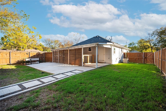 rear view of property featuring central AC unit, a lawn, a patio area, and a fenced backyard