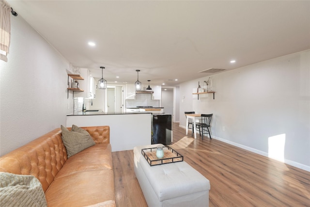 living room featuring baseboards, recessed lighting, visible vents, and light wood-style floors