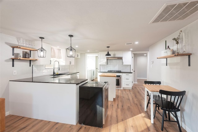 kitchen featuring visible vents, appliances with stainless steel finishes, white cabinetry, open shelves, and a sink